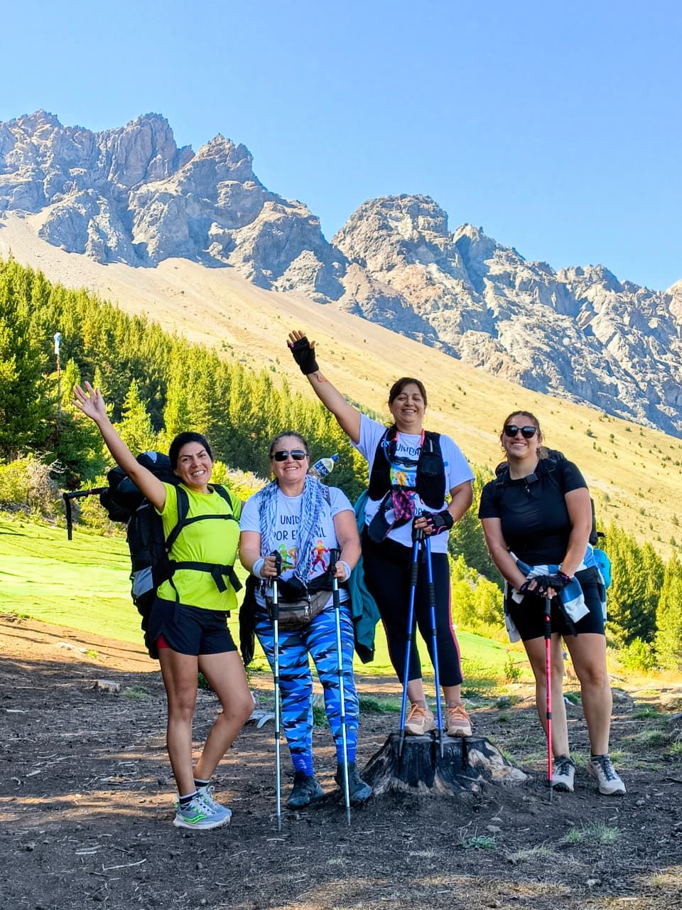 Grupo de pasajeras con bastones en el Cerro Piltriquitrón, con los picos de fondo